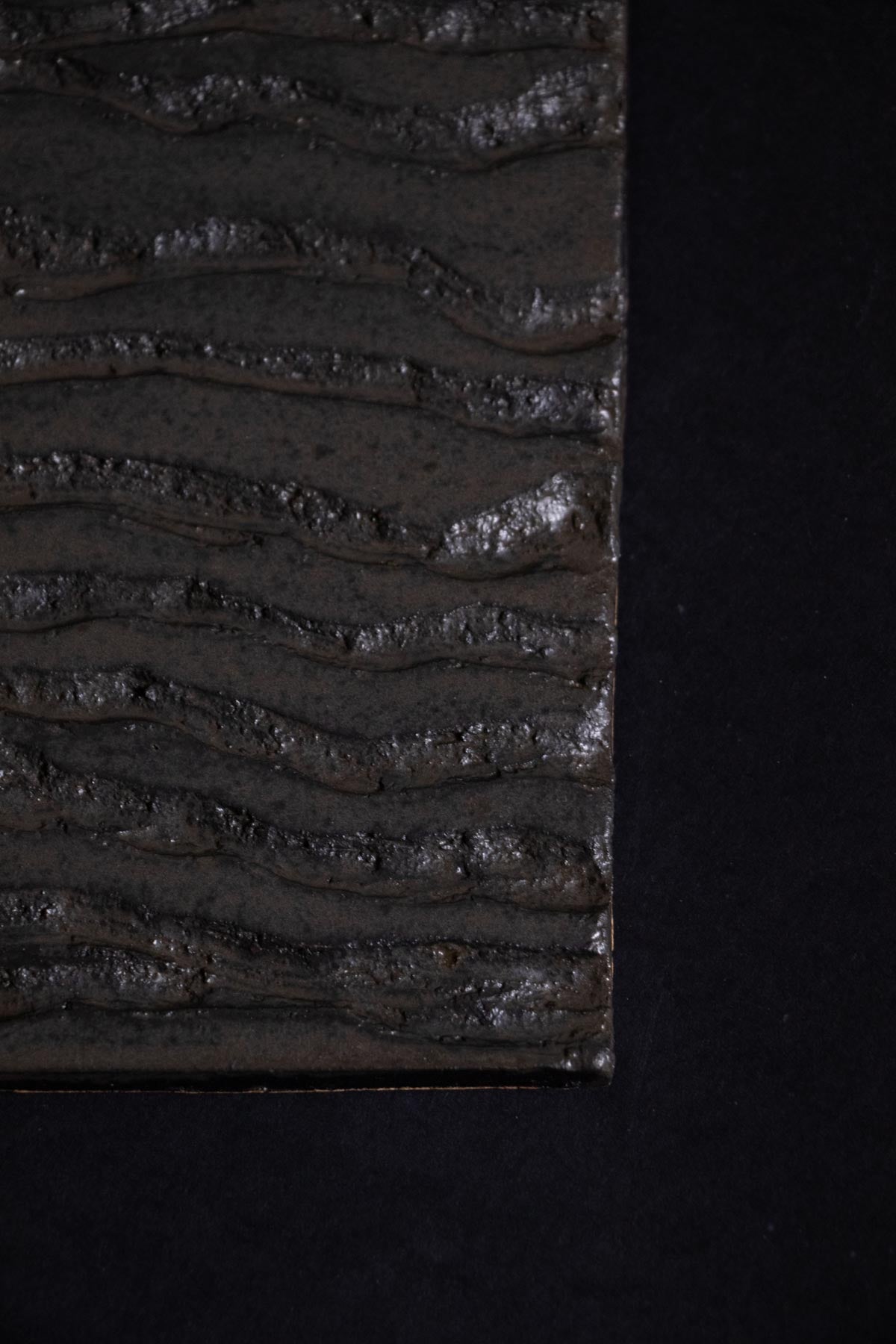 Close-up of a textured black surface with wavy patterns