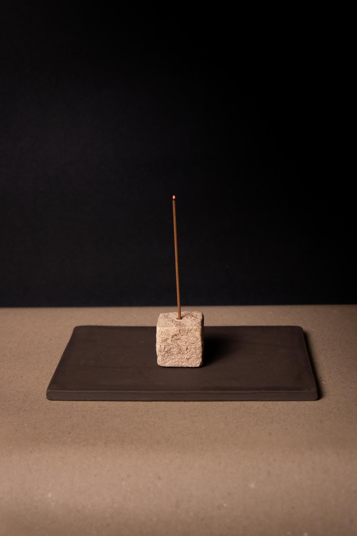 Incense burner, wabisabi style. Cream, textured cube on a flat, brown tray. Ceramic incense burner. Artistic incense burner.