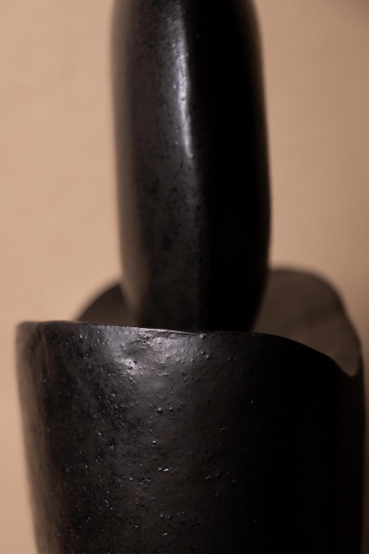 Close-up of black ceramic sculpture inspired by the moon. Minimalist stoneware sculpture. Minimalist decor. Decorative ceramics. New moon sculpture.