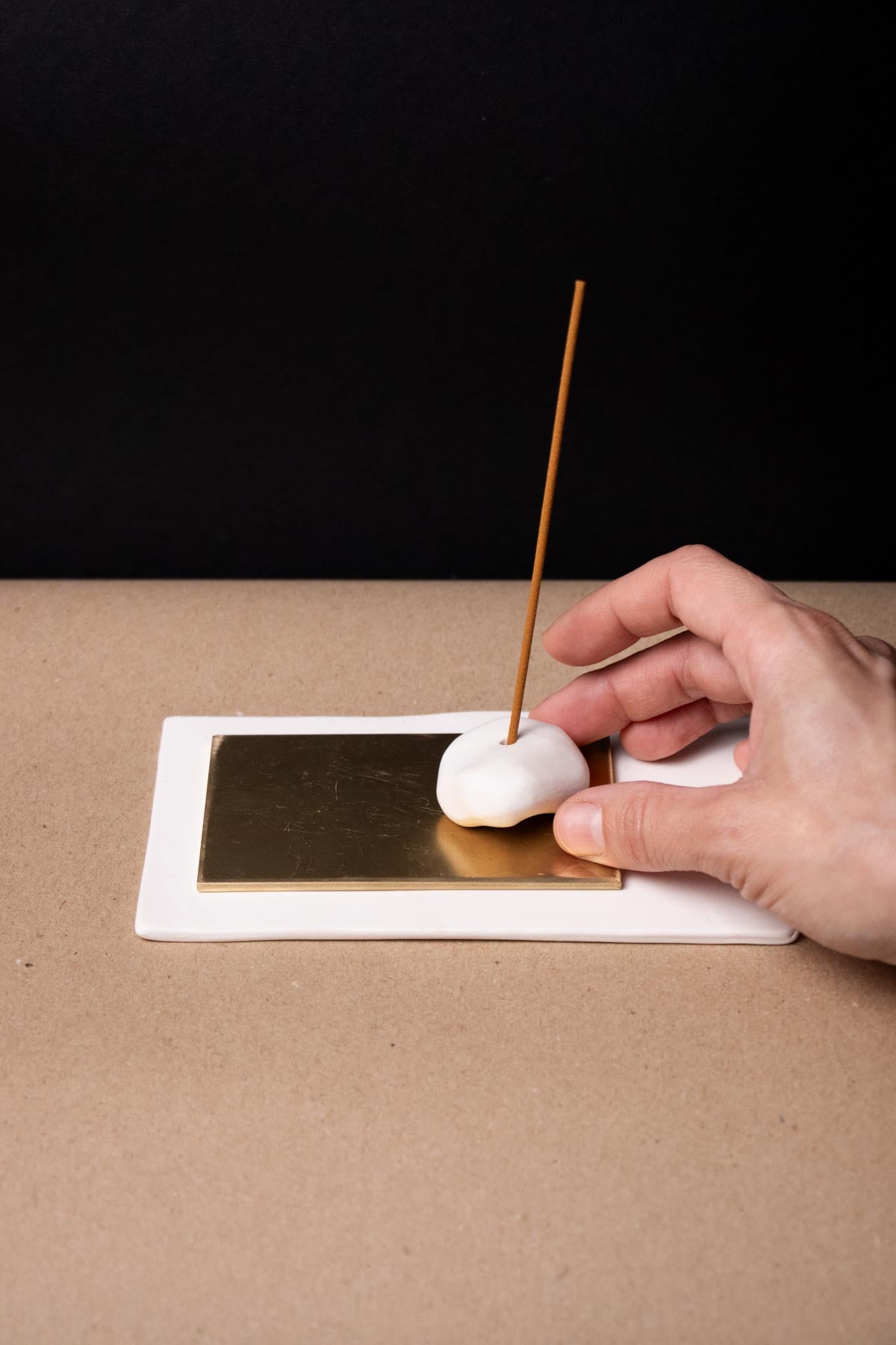 Hand holding pebble like incense stick holder. Ceramic incense burner. Design incense holder.