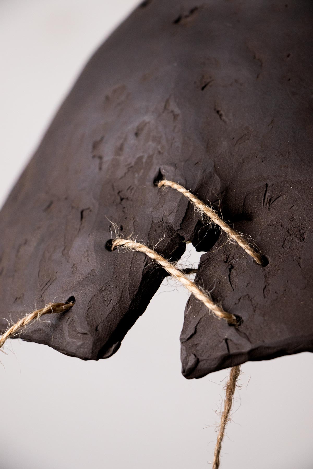 Close-up of a ceramic lamp. Dark brown lamp. Minimalist pendant lamp. Stoneware lamp.