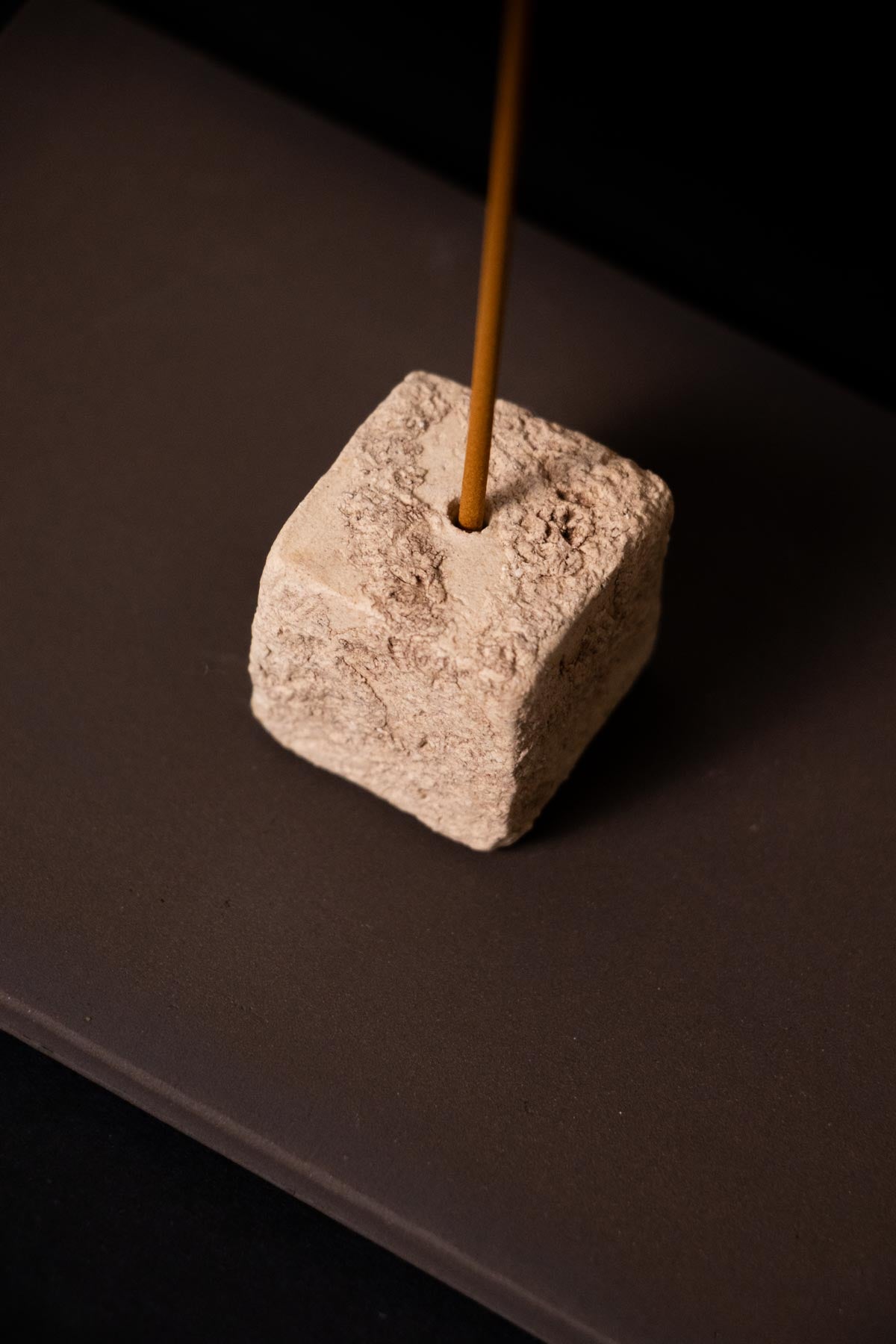 close up of a textured ceramic square. Incense stick holder. Incense burner. Artistic incense holder. cream and brown incense burner.