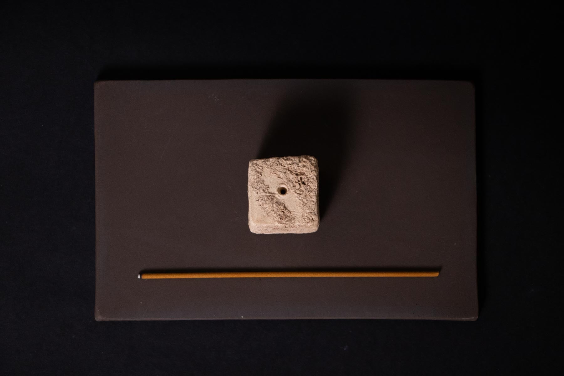 textured ceramic cube on a brown tray. artistic incense burner. Wabi sabi home décor