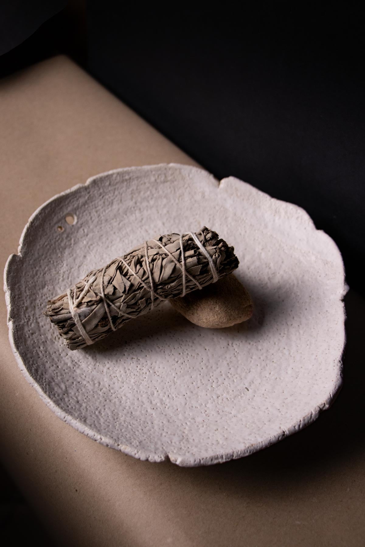 One bundle of white sage on a white ceramic plate. Ritual dish. Smudging ritual kit. Smudging accessories. Smudge stick.