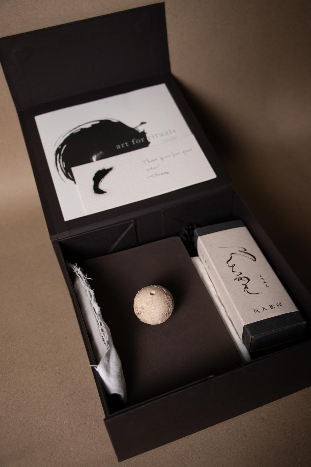 Ritual kit with ceramic incense holder, a box of Chinese incense sticks and a ritual guide with ink brushstrokes. Sanshiliangke incense.