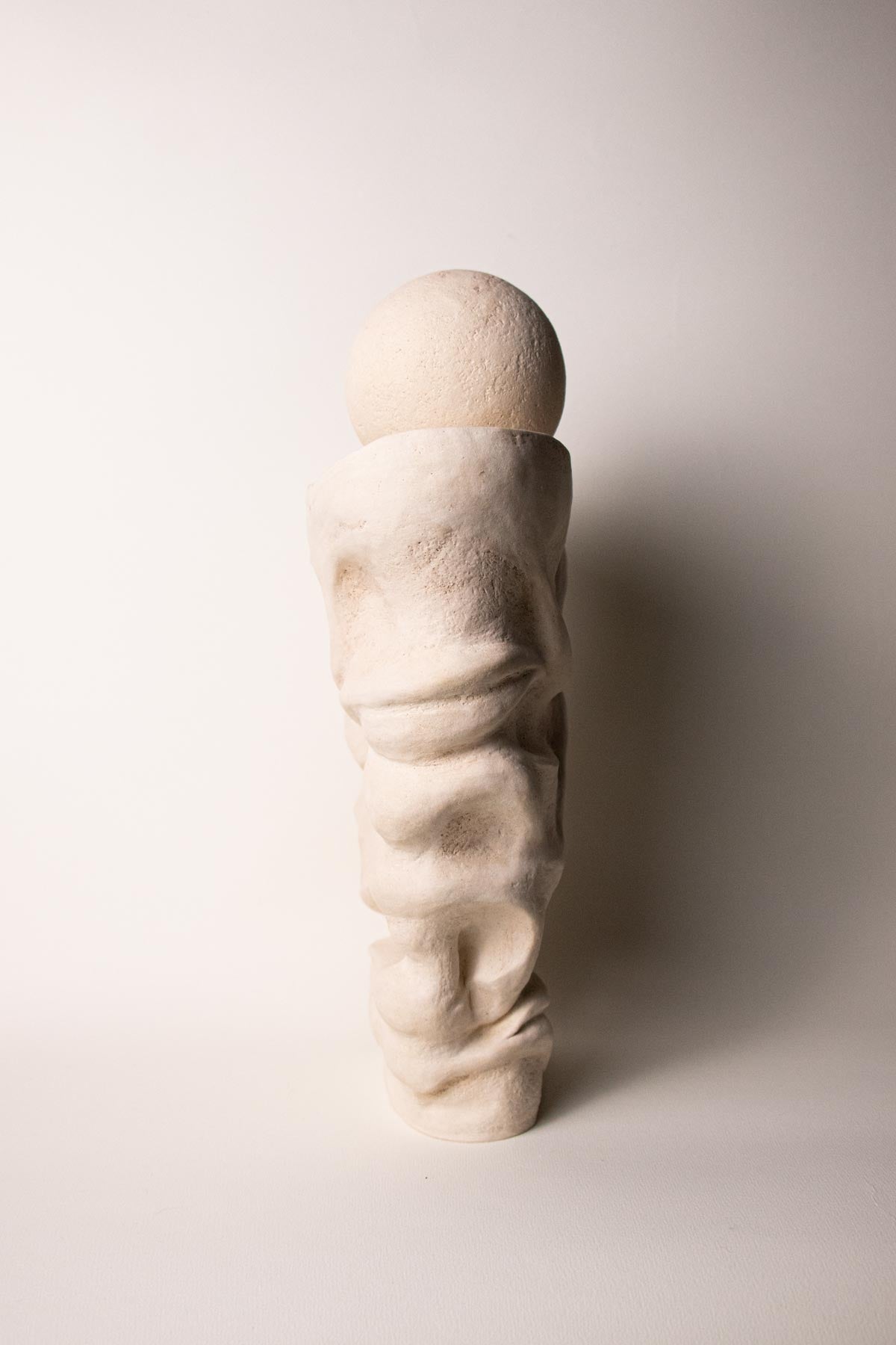 Side view of stoneware sculpture. White and cream sculpture. contemporary ceramics.