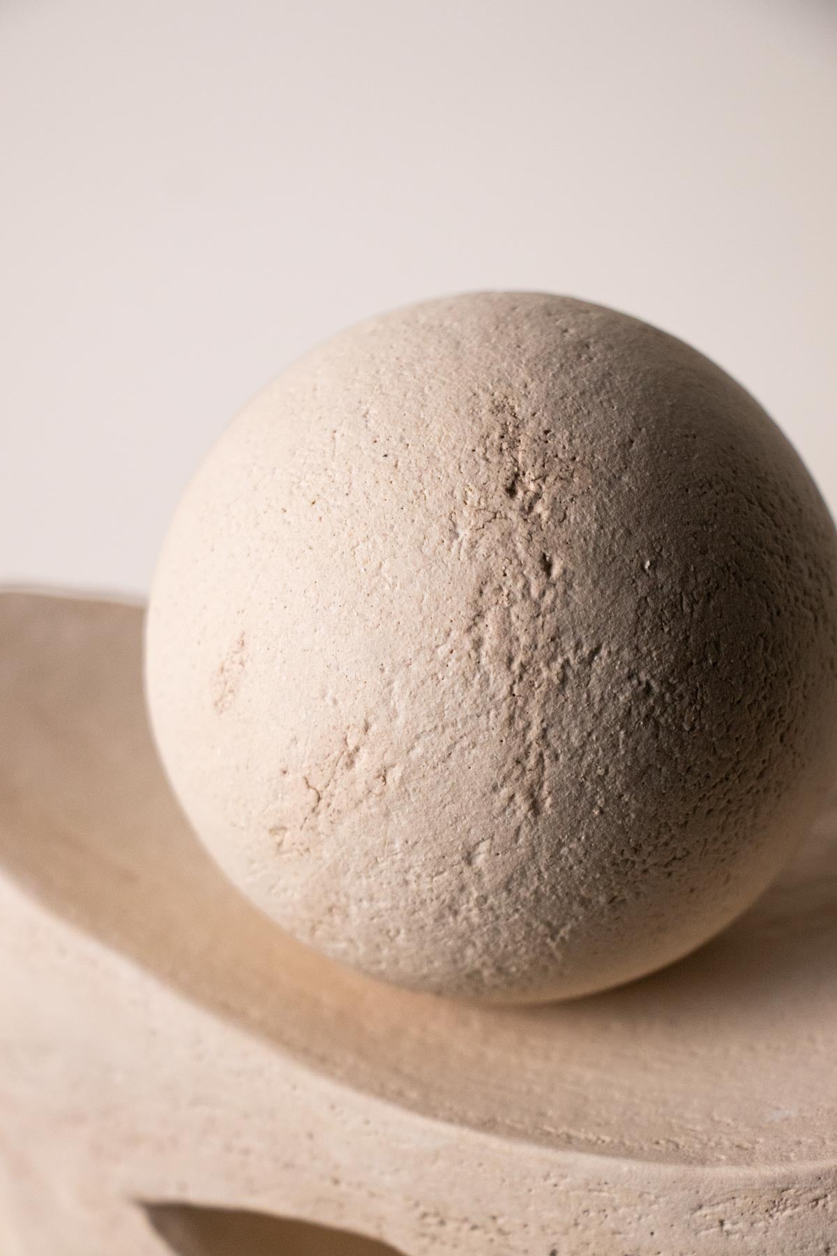 Close-up of ceramic texture on a stoneware sculpture. Cream stoneware. White stoneware. Contemporary ceramic sculpture. Handmade ceramics. Italian ceramics.