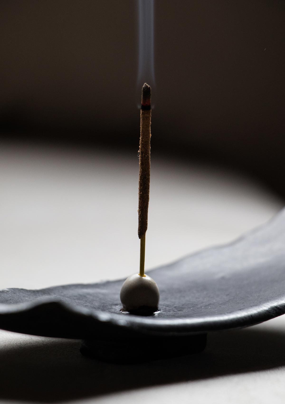 Luxury incense burner. Black incense burner. Handmade ceramic incense burner by Claire Lune. Styled on issue of Ark Journal. Detail of smoke in dim light.